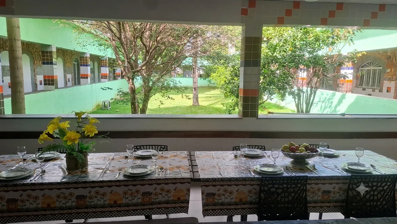 Refeitório da Amor em Foco com mesas postas e vista para o jardim
